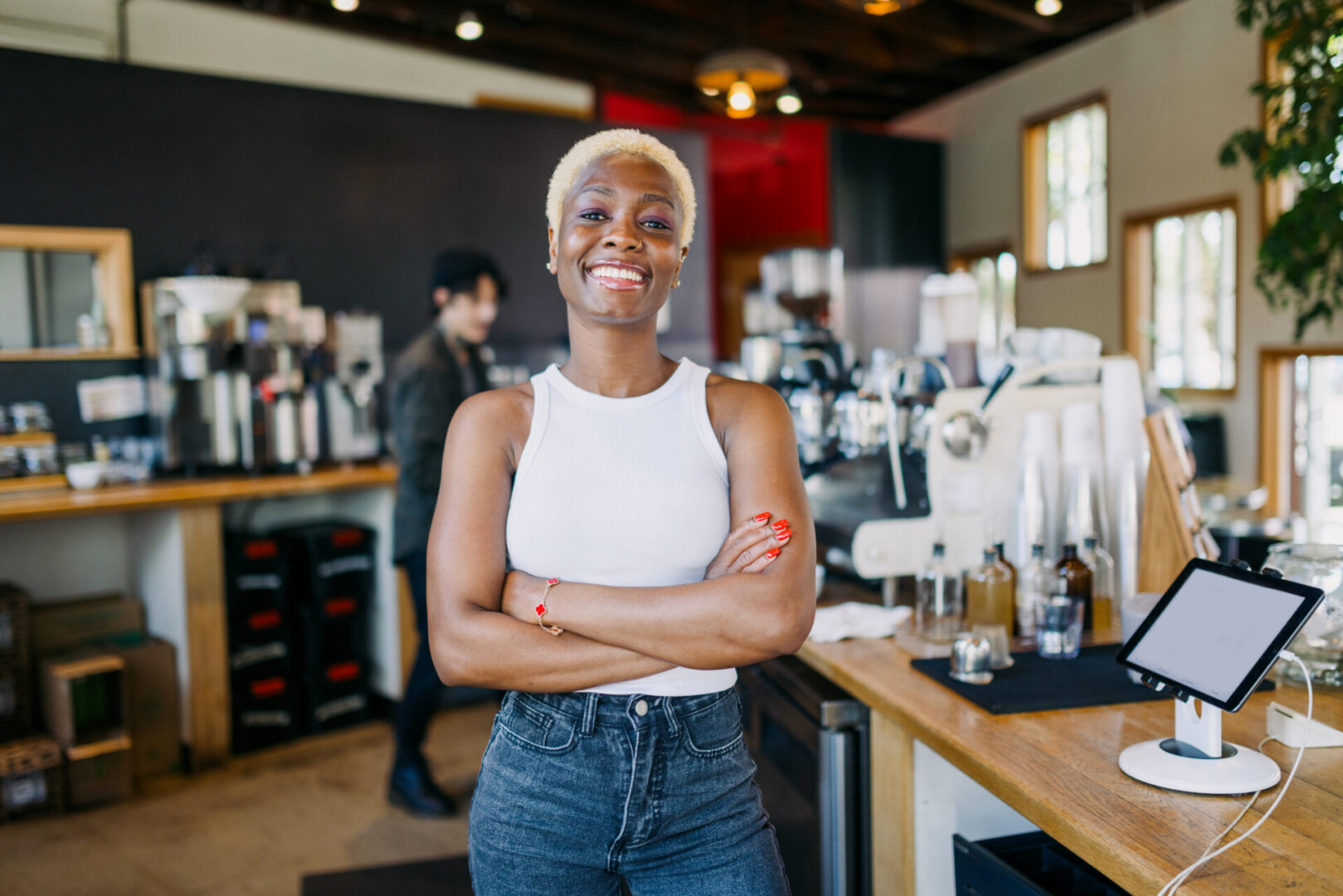 A smiling African American woman in her place of work, a bright urban cafe serving single origin coffee and espresso.  Shot in Portland, Oregon.