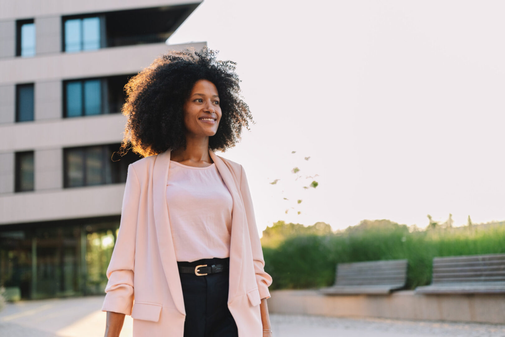 Smiling woman outdoors near modern building.
